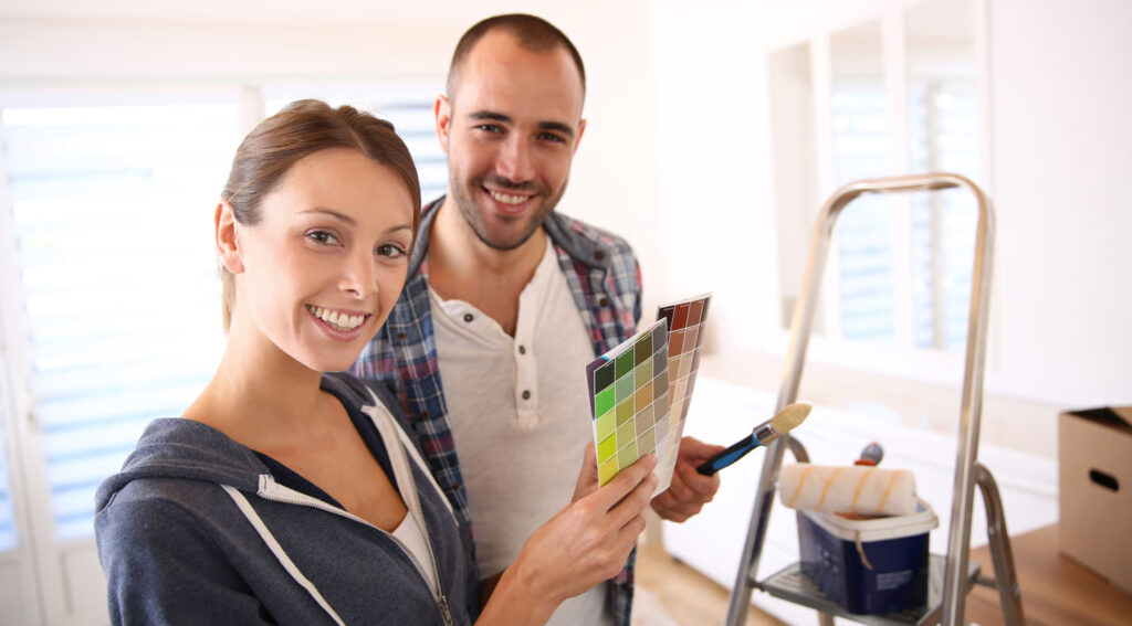 House painter in Mississauga painting a living room wall with floors covered